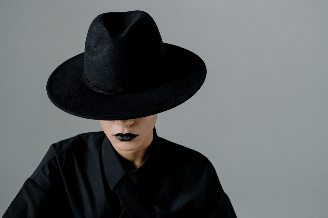 Woman in Black Clothing and Black Hat